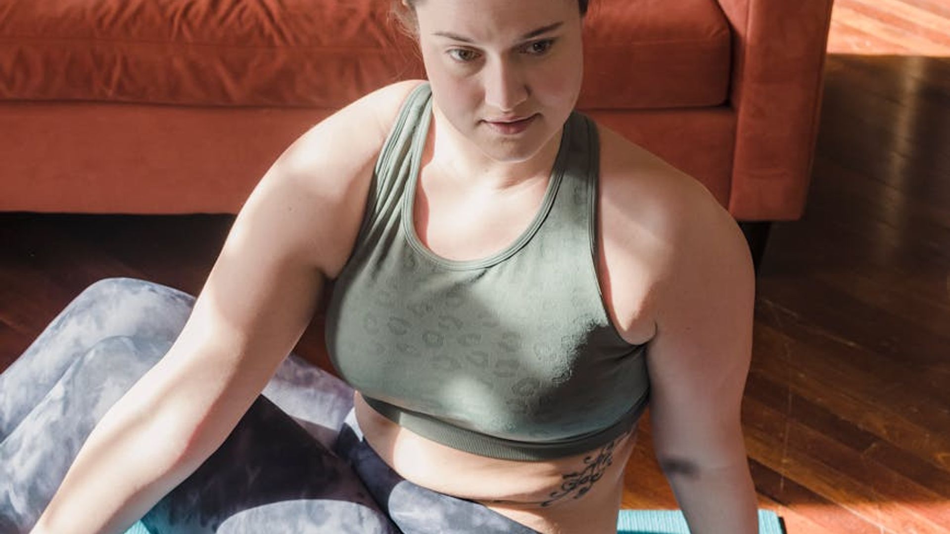 Serene woman practicing gentle stretching exercises in a dark room